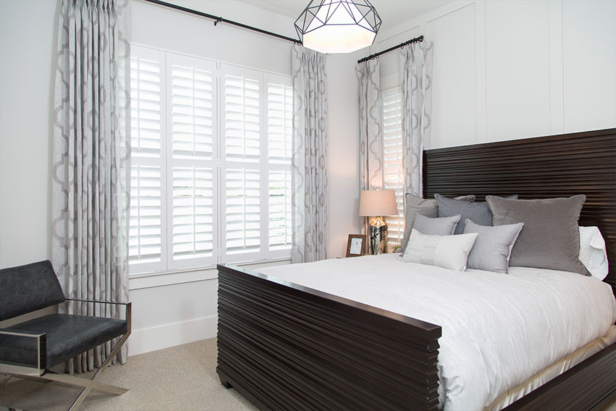 Closed white Polywood shutters on bedroom windows