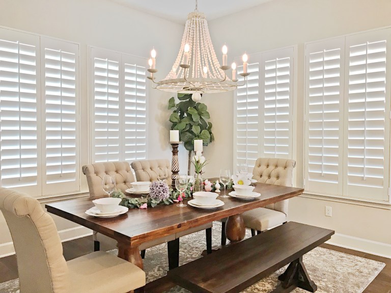 Plantation shutters in dining room with beaded chandelier