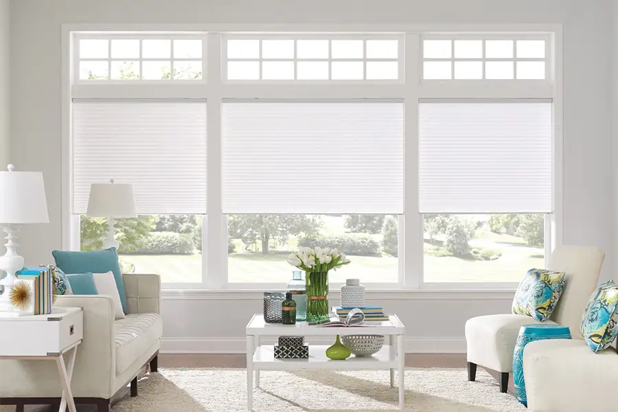 Insulating cellular shades can help keep cold air and hot UV rays from entering your Cleveland home. White cellular shades on windows in a white living room
